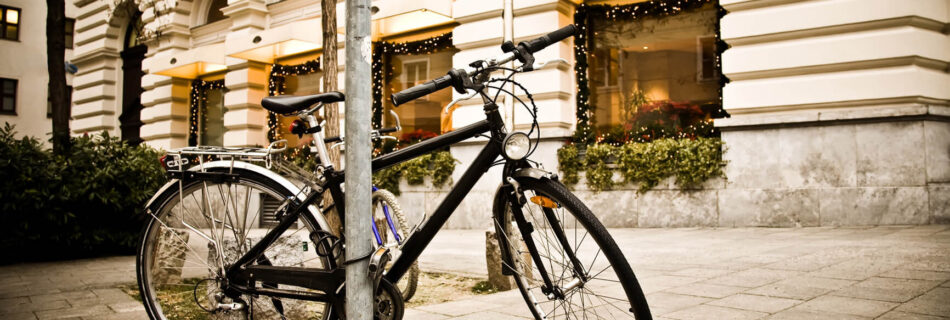 Black bicycle parked in front of building.