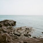 Rocky shore with ocean in background.