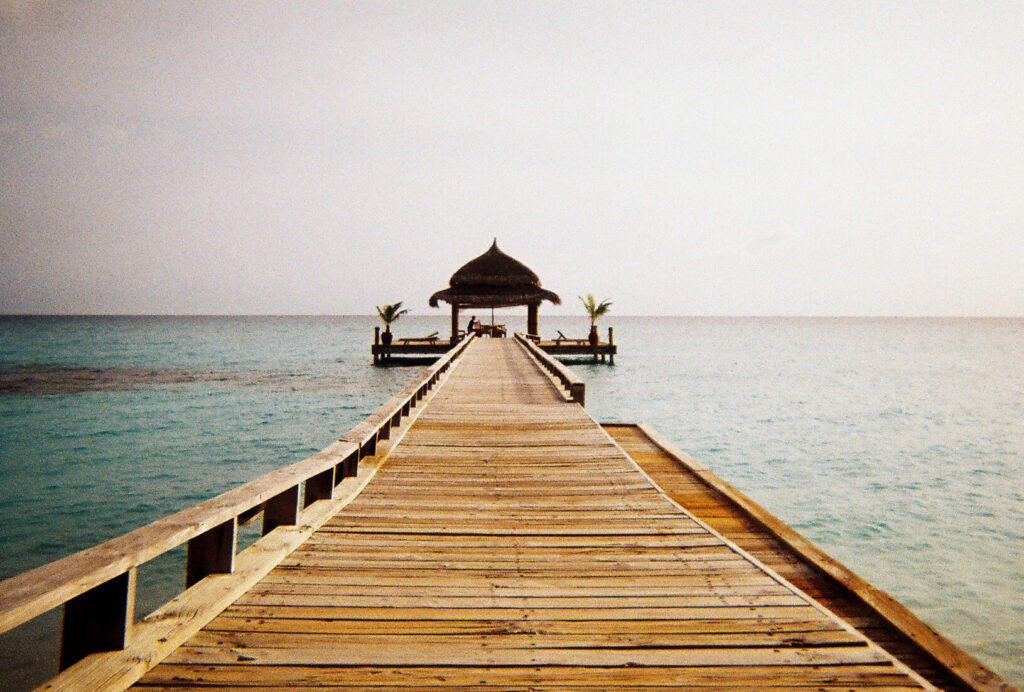 Wooden pier extending into turquoise ocean.