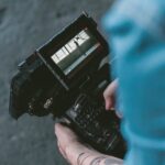 Person filming a scene with a camera.